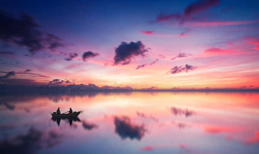 two person on boat in body of water during golden hour