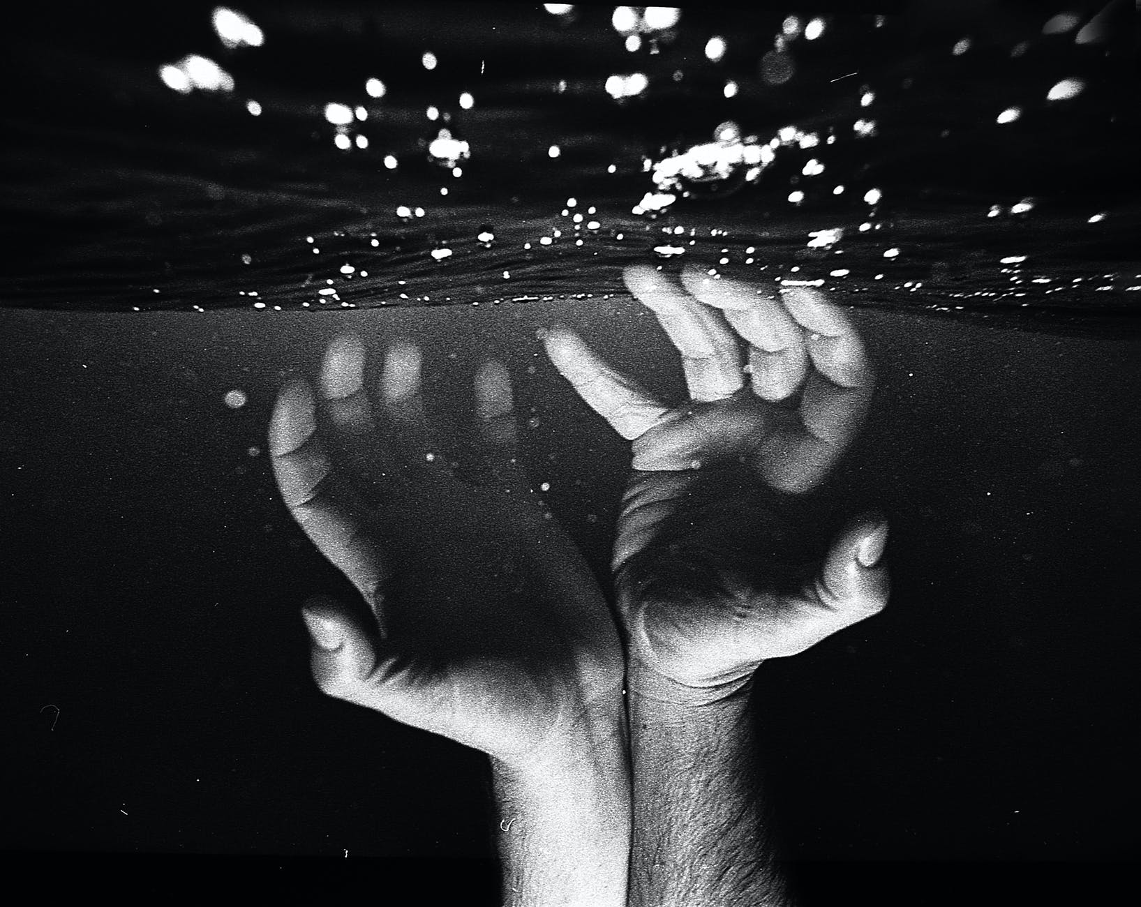 hands of crop faceless man under water